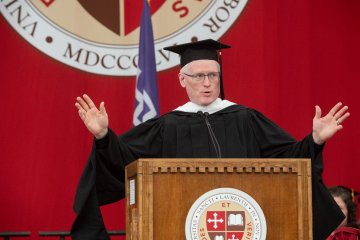 A speaker in academic regalia delivers a commencement address at a St. Lawrence University graduation ceremony.