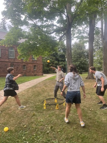 College students playing spike ball outside