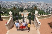 Six students hold a red Saint Lawrence University in front of an impressive city view while studying abroad. 