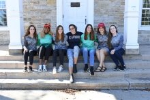 A photo of many St Lawrence students sitting on the stairs of Sykes Hall, each donning a Gretchen Scott clothing item.