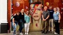 A photo of St Lawrence students standing outside of a David Bowie mural.