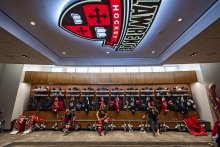 A locker room with the St. Lawrence athletic shield lit up on the ceiling.